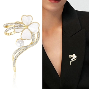 Elegante spilla a fiore dorata con petali di madreperla e perla su un blazer nero