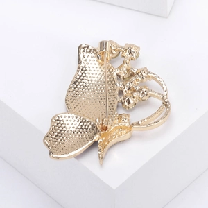 Detail view of the gold-plated butterfly brooch back with secure pin and matte texture