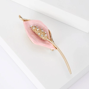 Détail de la broche calla en émail rose avec strass brillants sur monture dorée élégante