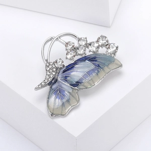 Close-up of enamel butterfly brooch with blue gradient and sparkling rhinestones