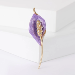 Détail macro d'une broche calla avec émail violet et pistils incrustés de strass