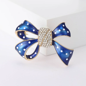Broche nœud en émail bleu à pois blancs et cristaux sur monture dorée élégante