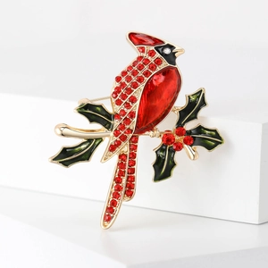 Détail de la broche cardinal rouge avec feuilles de houx en émail et cristaux brillants