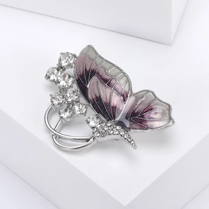 Detail of silver butterfly brooch with purple enamel and inlaid crystals on wings