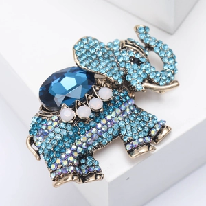 Detailed view of vintage elephant brooch with blue rhinestones and gold-tone metal base