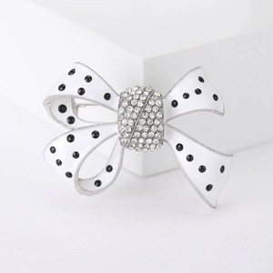 Broche nœud élégante en émail blanc à pois noirs avec cristaux brillants sur alliage argent