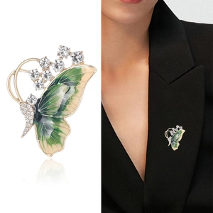 Exquisite gold-tone butterfly brooch with green enamel wings and sparkling crystals