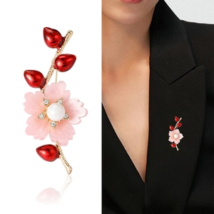 Elegante Blumenbrosche mit rosa Blütenblättern und weißen Perlen an goldener Nadel