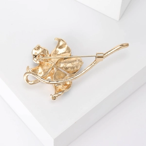 Elegant gold flower brooch back view with secure pin clasp on stylish white background