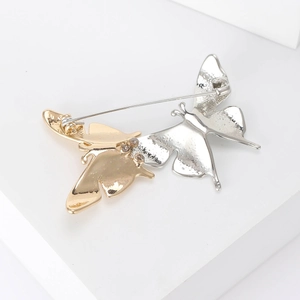 Elegante spilla a farfalla bicolore oro e argento con trama martellata e piccoli strass