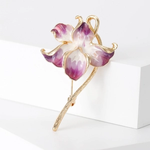 Elegant purple and white enamel flower brooch with golden metal trim on white background