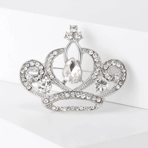 Détail d'une broche couronne argentée sertie de cristaux sur des marches blanches