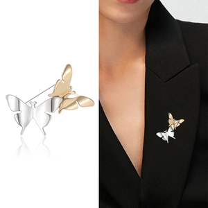 Elegante spilla a farfalla bicolore con lucidatura a specchio su revers di abito nero