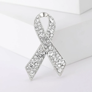 Détail macro d'une broche ruban en alliage argenté avec strass en cristal étincelants