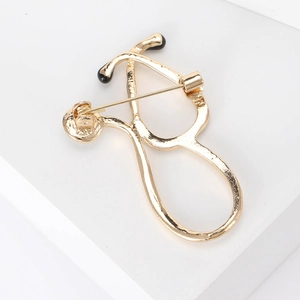 Creative gold stethoscope brooch with hammered texture and black bead accents
