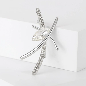Detailed macro view of silver rhinestone brooch with marquise-cut crystal on white stand