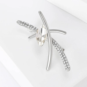 Detail view of a silver X-shaped brooch featuring a large marquise-cut crystal and rhinestones