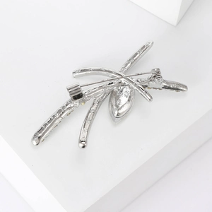Detail view of silver brooch back showing safety pin clasp and botanical branch structure