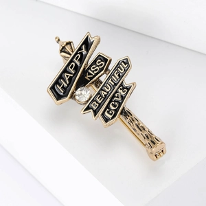 Détail d'une broche vintage en forme de panneau avec textes Happy Kiss Love et cristal
