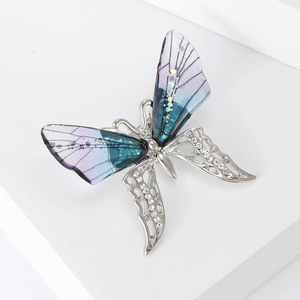 Detailed macro view of butterfly brooch with rhinestones and blue gradient wings
