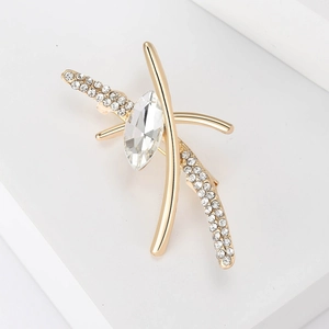 Close-up of golden brooch with marquise-cut crystal and sparkling rhinestone accents