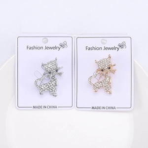 Close-up of cute cartoon cat brooches in gold and silver finish with white rhinestones
