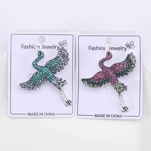Detailed close-up of crane brooches with colorful rhinestones on fashion display cards