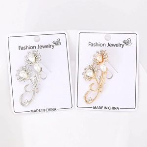 Macro detail of sunflower brooches with pearls and rhinestones in gold and silver finish