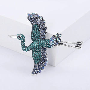 Macro shot of silver alloy flying crane brooch with colorful rhinestone details