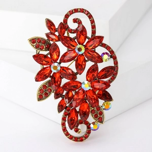 Detail of red marquise crystal floral brooch with vintage gold alloy vine and crystals
