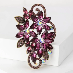 Detailed close-up of a large purple crystal flower brooch with vintage gold finish