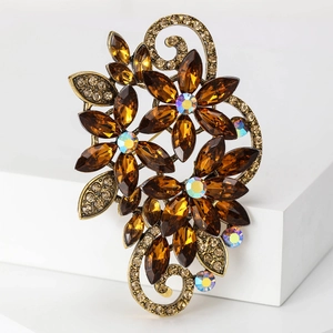 Detailed macro of a vintage bronze flower brooch with amber crystals and rhinestones