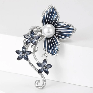 Detailed view of navy blue floral brooch with rhinestones and white pearl on a clean pedestal