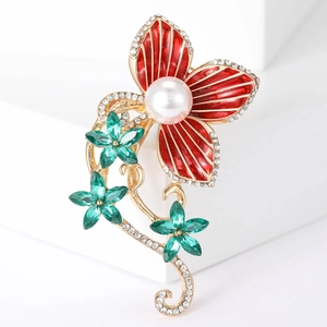 Detailed macro view of enamel flower brooch with red petals and white center pearl