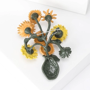 Back view of sunflower brooch with metal pin clasp detail on white geometric base