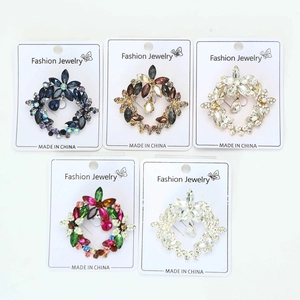 Macro detail of five crystal wreath brooches in assorted colors on fashion jewelry cards