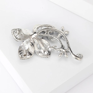 Silver camellia flower brooch with oil drip and rhinestones shown from a back view