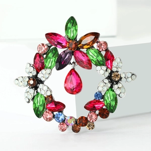 Detailed close-up of crystal floral wreath brooch with vibrant multicolored gemstones