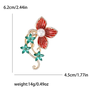 Red enamel camellia flower brooch with green gemstones and white pearl accents