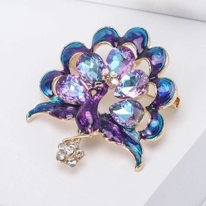 Detail of luxury peacock brooch with purple enamel wings and sparkling rhinestones