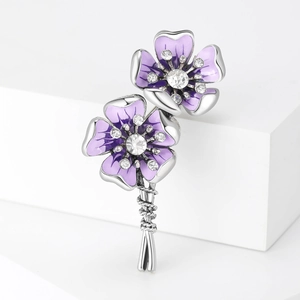 Detailed macro of a purple enamel floral brooch with silver plating and crystal rhinestones