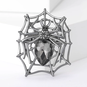 Detailed macro view of gothic spider web brooch with pear-cut black crystal and rhinestones
