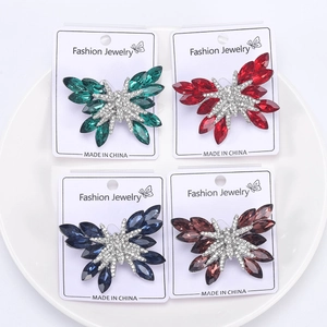 Dettaglio di quattro spille a farfalla con strass in verde rosso blu e viola vivace
