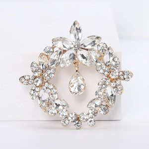 Detailed macro view of a sparkling crystal flower wreath brooch with a teardrop pendant