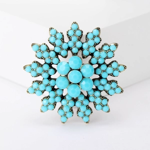 Macro shot of vintage Turkish blue beaded brooch with antique gold snowflake pattern