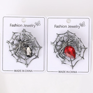 Detailed pair of spider brooches with red and grey crystals on vintage silver metal