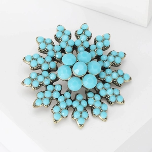 Close-up of vintage baroque sun flower brooch with turquoise beads and bronze metal base