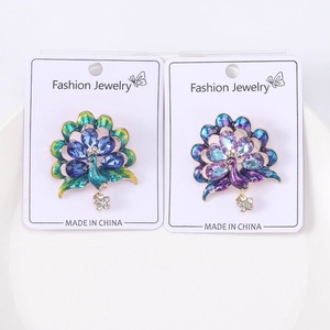 Detail of luxury peacock brooches with sparkling crystals and colorful enamel inlays