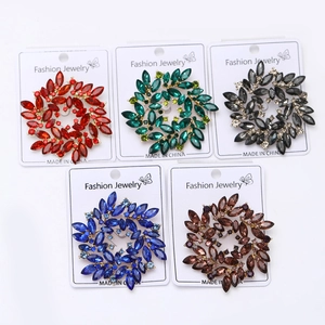 Set of five hollow round crystal brooches in assorted colors with gold metal base