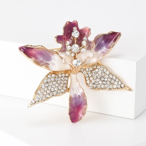 Detailed macro of orchid brooch with purple gradient enamel and sparkling rhinestones